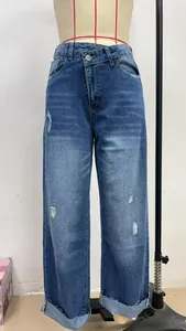 Detail view of women's washed straight-leg denim jeans with ripped design on mannequin
