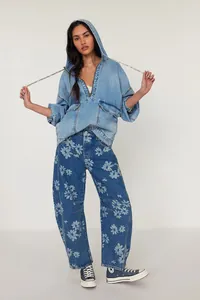 Detail view of women's loose barrel jeans with floral pattern and denim hoodie