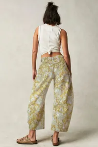 Back view of woman wearing floral patterned wide-leg trousers and a white ribbed top