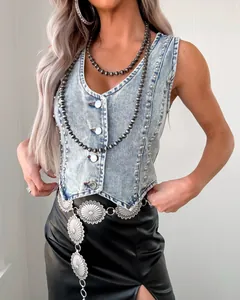 Vue détaillée d'un gilet en jean à clous avec jupe en cuir et accessoires argentés.