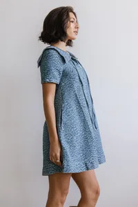 Zijaanzicht van een blauwe denim jurk met luipaardprint en stijlvolle vintage kraag