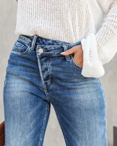 Detail view of women's washed straight denim jeans featuring an asymmetrical button fly.