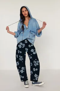 Full view of women's floral print barrel jeans paired with a casual denim hoodie jacket