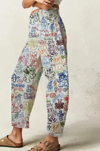 Detail view of colorful all-over doodle print on off-white barrel-leg denim jeans.