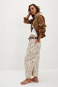 Full body shot of women's loose mid-waist barrel jeans with vintage floral cat print