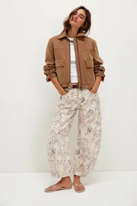 Full-length view of loose-fit barrel jeans featuring a faded floral cat print for casual styling