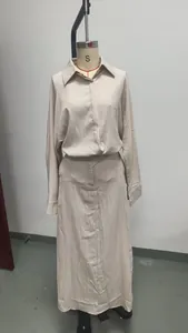 Vista dettagliata del completo beige due pezzi con camicia a maniche lunghe e gonna lunga