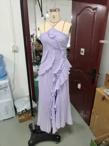 Detail view of a purple pleated halter-neck dress with ruffles on a mannequin