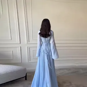 Elegant light blue long-sleeved maxi dress with back lace-up detail and flowing ruffles