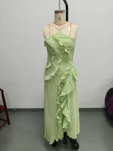 Close-up detail of light green pleated halter dress featuring layered ruffles on mannequin