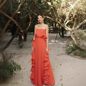 Elegant orange pleated strapless maxi dress with romantic ruffles for summer vacay.