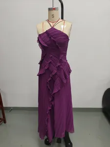 Detail view of a purple pleated halter neck maxi dress with elegant ruffles on a mannequin