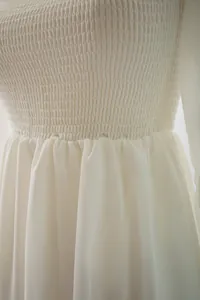 Primer plano del corpiño fruncido blanco y cintura recogida de vestido largo elegante
