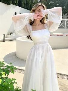 Elegante vestido largo blanco con mangas abullonadas, escote cuadrado y falda de verano