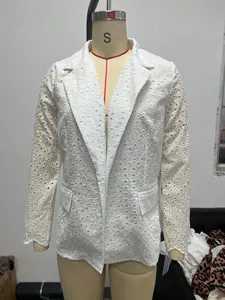 Detailed macro view of intricate white eyelet lace embroidery on a fashionable slim blazer