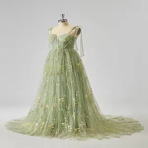 Detailansicht eines salbeigrünen Abendkleids mit Blumenstickerei aus Tüll auf einer Puppe