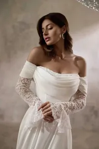 Detail eines eleganten weißen schulterfreien Hochzeitskleids mit Spitzenärmeln