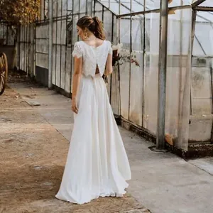 Back view of a bohemian lace bridal wedding dress featuring a flowing long satin skirt
