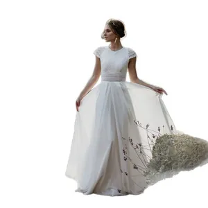 Detailed view of an elegant minimalist white lace wedding dress with flowing skirt
