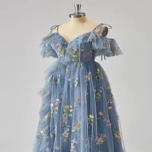 Close-up view of a dusty blue tulle evening gown with intricate floral embroidery details