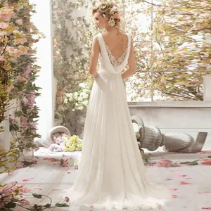 Back view of lace bridal gown with deep V open back in a romantic floral garden setting