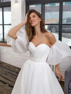 Elegant off-the-shoulder white dress with voluminous puff sleeves and sweetheart neckline