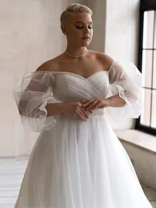 Elegant off-the-shoulder wedding dress with pleated puff sleeves and A-line tulle skirt