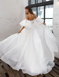 Detailed back view of an elegant off-the-shoulder white wedding dress with puff sleeves