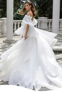 Elegant French style off-shoulder wedding dress with puff sleeves and flowing skirt.