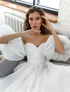 Detail view of white strapless wedding dress with elegant organza puff sleeves