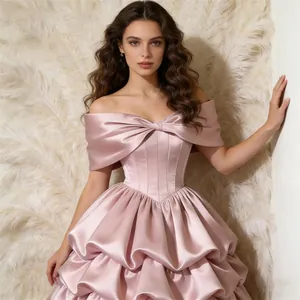 Elegante roze satijnen avondjurk met blote schouders grote strik en gelaagde rok voor feesten