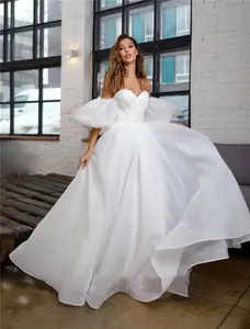 Elegant white off-the-shoulder wedding dress with puff sleeves for parties and events.