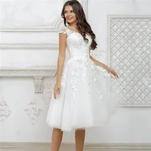 Full view of elegant white knee-length bridal dress with floral lace applique details