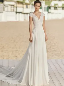 Dettaglio dell'elegante corpetto in pizzo e dello scollo a V di questo abito da sposa bianco.