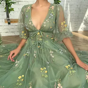 Macro view of exquisite floral embroidery on a green tulle evening gown with V-neckline