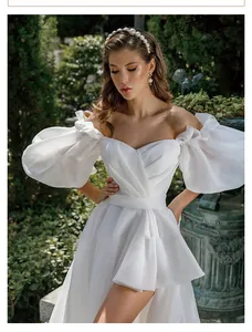 Detail view of white off-the-shoulder bridal gown featuring voluminous puff sleeves.