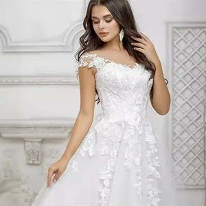 Elegant white lace wedding dress with cap sleeves and delicate floral embroidery details
