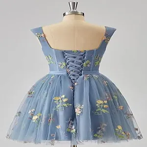 Back detail of a dusty blue short dress featuring floral embroidery and lace-up design