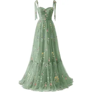 Elegant sage green tulle maxi dress featuring floral embroidery and tie straps.