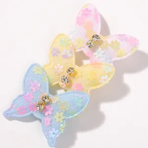 Detalle de tres pinzas para el cabello de mariposa de encaje con lentejuelas para bebés.