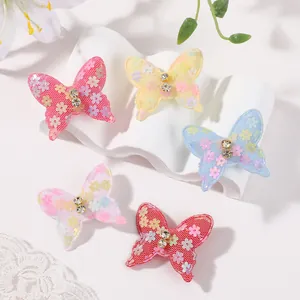 Vista detallada de pinzas para el cabello de mariposas de encaje con brillantes.