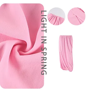 Détail d'une jupe longue en mousseline rose avec texture plissée et taille