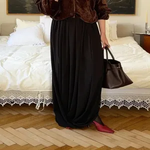Jupe longue élégante en mousseline noire avec un drapé gracieux dans un décor chaleureux