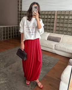 Vue détaillée de la jupe longue plissée en mousseline rouge avec un t-shirt blanc