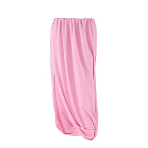 Détail d'une jupe longue rose en mousseline avec des plis élégants et taille élastique.