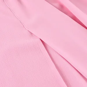 Gros plan macro du tissu en mousseline rose élégant montrant la texture douce et la fluidité