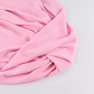 Gros plan sur un tissu en mousseline rose avec une texture plissée élégante