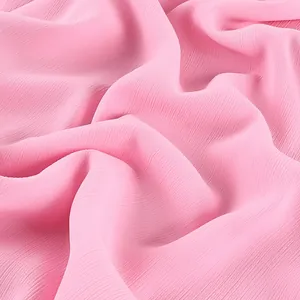 Gros plan de haute qualité du tissu mousseline rose avec drapé élégant et plis doux.