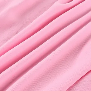 Vue macro détaillée d'un tissu en mousseline plissé rose de haute qualité et doux