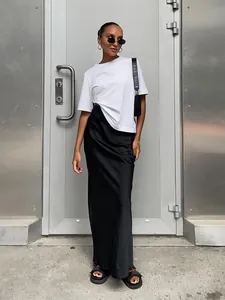 Vue détaillée d'une jupe longue en satin noir minimaliste avec un t-shirt blanc